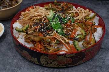 Scattered sushi chirashisushi served in traditional japanese bowl on gray table, side dishes, copy space