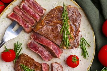 Pieces of delicious beef meat, spices and tomatoes on table, top view