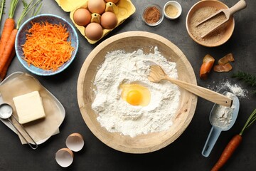 Making carrot cake. Different ingredients for dough and kitchenware on dark textured table, flat lay