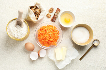Different ingredients for making carrot cake on beige textured table, flat lay