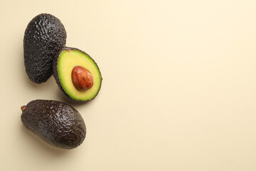 Fresh ripe avocados on beige background, flat lay. Space for text