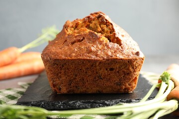 Tasty carrot cake and vegetables on grey table, closeup