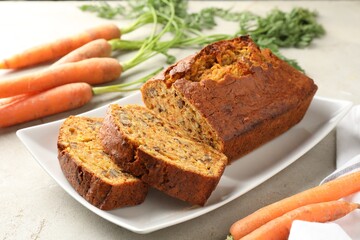 Homemade carrot cake with nuts and vegetables on light grey table, closeup