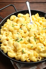 Delicious pasta with cheese sauce on wooden table, closeup