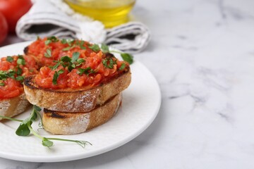 Tasty bread with tomato and parsley on white marble table, closeup. Space for text