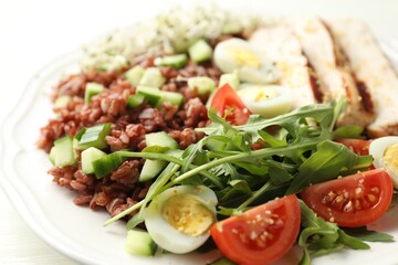 Delicious salad with brown rice on white table, closeup