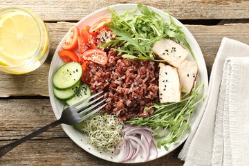 Delicious salad with brown rice and drink on wooden table, flat lay
