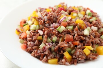 Tasty salad with brown rice on white table, closeup