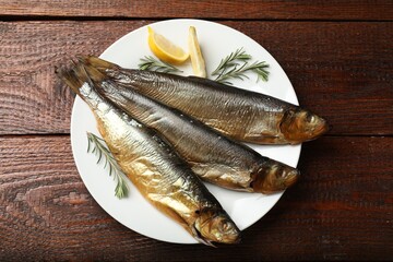 Smoked herrings, rosemary and lemon on wooden table, top view