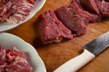 Freshly cut beef on wooden surface with knife ready for culinary preparation in kitchen setting