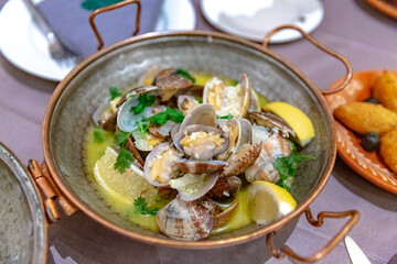 Ameijoas à Bulhão Pato, Portuguese clams in white wine sauce with lemon and herbs, served in a rustic bowl, highlighting Mediterranean flavors