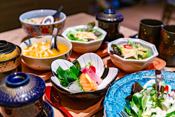 Traditional Japanese breakfast set with rice, soup, pickled vegetables, and assorted side dishes, presented in ceramic bowls on a wooden tray
