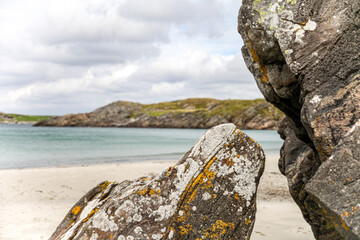 A rocky beach in Norway with a large rock in the foreground