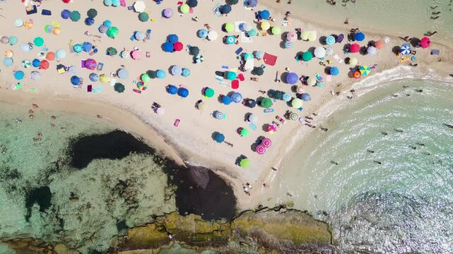 Estate a San Pietro in Bevagna, Manduria, Salento, Puglia.  Spiaggia di Ombrelloni Colorati e il mare turchese