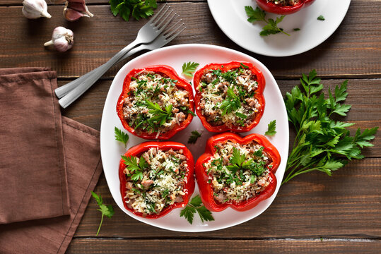 Baked stuffed red bell peppers with minced meat, rice, parmesan cheese on plate