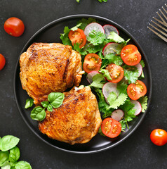 Roasted chicken thighs with vegetables on plate