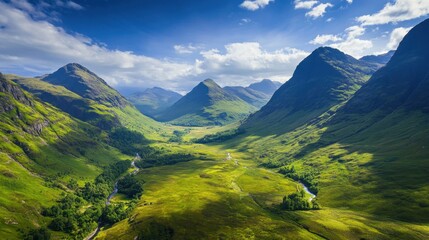 Picturesque aerial shot of Glencoes green valleys and distant mountain ranges under a blue sky