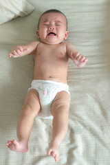 Baby crying on a bed