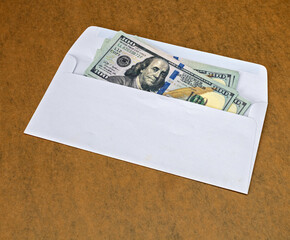 Cash Overflow: An overhead shot revealing a bundle of crisp hundred-dollar bills spilling out of an open envelope, inviting viewers to contemplate themes of finance and windfall.