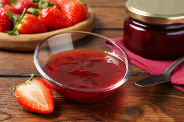 Delicious strawberry sauce and fresh berries on wooden table, closeup