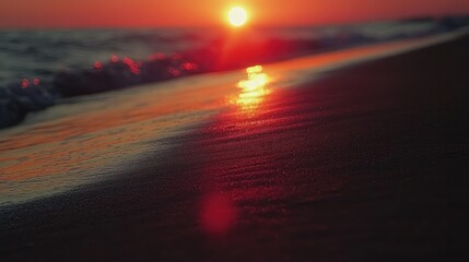 The setting sun reflects its light upon wet ocean sand