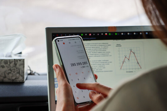 woman counts expenses on calculator in smartphone