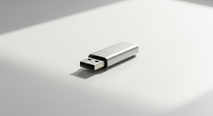Fototapeta premium Elegant silver USB drive capturing natural light on a clean white backdrop