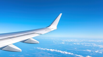 Obraz premium A clear view of an airplane wing soaring above a vast expanse of clouds under a bright blue sky.