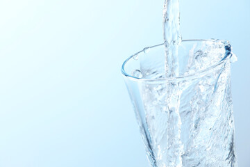 Pouring soda water into glass on light background, closeup. Space for text