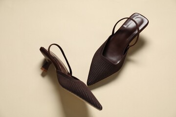 Stylish brown shoes on beige background, flat lay