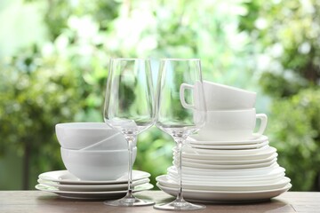 Clean dishware on wooden table against blurred background