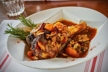 braised pork shank topped with sweet potato, olives, and slivered almonds and topped with gravy