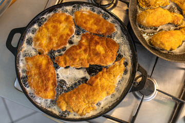 Crispy Breaded Chicken Filets Frying in a Hot Sizzling Pan