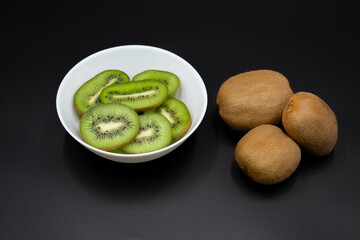 Kiwi on wooden background. Whole fruit and slices pieces of green kiwi on table. fresh ripe juicy kiwi. Tropical fruit. Organic fruit. Healthy eating