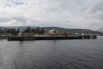 Victorian Dunoon timber ferry pier in Scotland, Category A listed wooden structure in Firth of Clyde closed to public needs renovation. Pretty historic landmark buildings on greenheart timber piles 