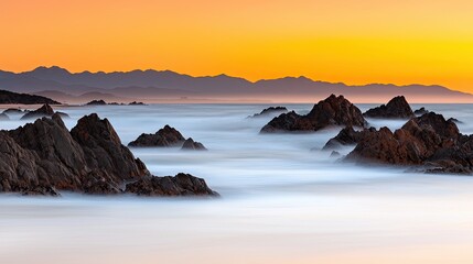 Sunset over rocky shoreline coastal landscape long exposure photography tranquil environment serene viewpoint