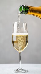 Sparkling champagne is poured into a tall elegant glass against a neutral background showcasing the effervescence and golden hue of the celebratory drink.