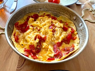 Turkish scrambled egg with red pepper or bell pepper in copper with turkish tea