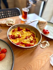 Turkish scrambled egg with red pepper or bell pepper in copper with turkish tea