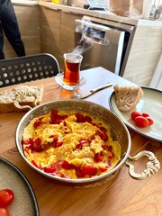 Turkish scrambled egg with red pepper or bell pepper in copper with turkish tea