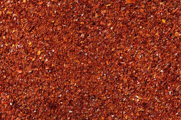 Spicy ground chili pepper close-up texture top view
