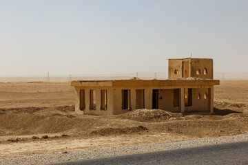 Abandoned building in the Afghan desert landscape under a clear sky