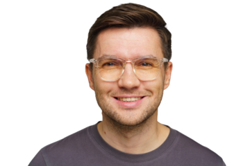 Smiling man wearing glasses against a plain background during a casual indoor setting