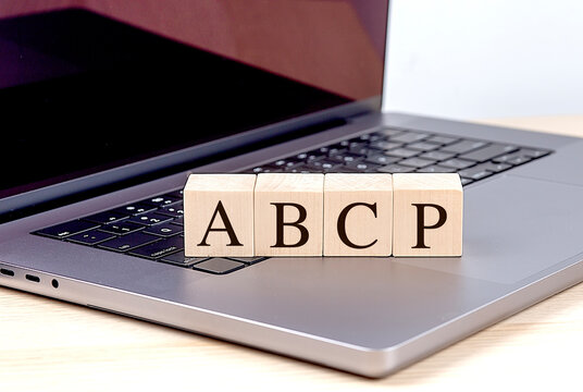 Wooden blocks with letters ABCP on laptop keyboard, representing asset-backed commercial paper