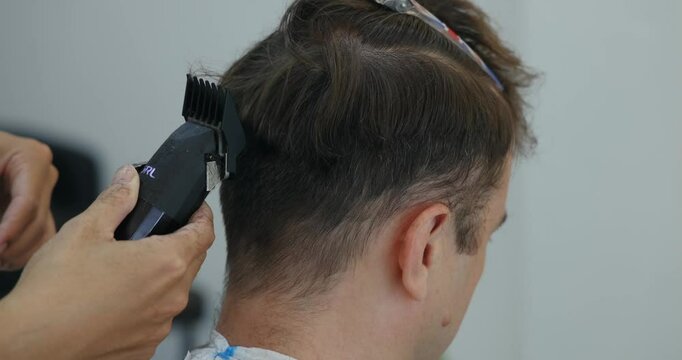 Haircut clippers barber styling client hair trim, men's grooming professional service precision cut technique.