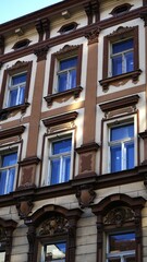 Building facade. Multiple windows. Ornate architectural style. Sunlit exterior.

