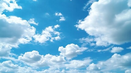 Obraz premium A bright blue sky filled with fluffy white and gray cumulus clouds.