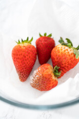 Fresh and Moldy Strawberries in a Glass Bowl on a White Napkin
