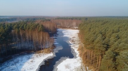 An aerial view of a river running through a snowy, wooded landscape.
