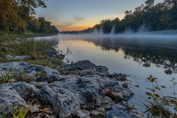 Fototapeta premium Tranquil dawn river scene with mist rising and colorful sky